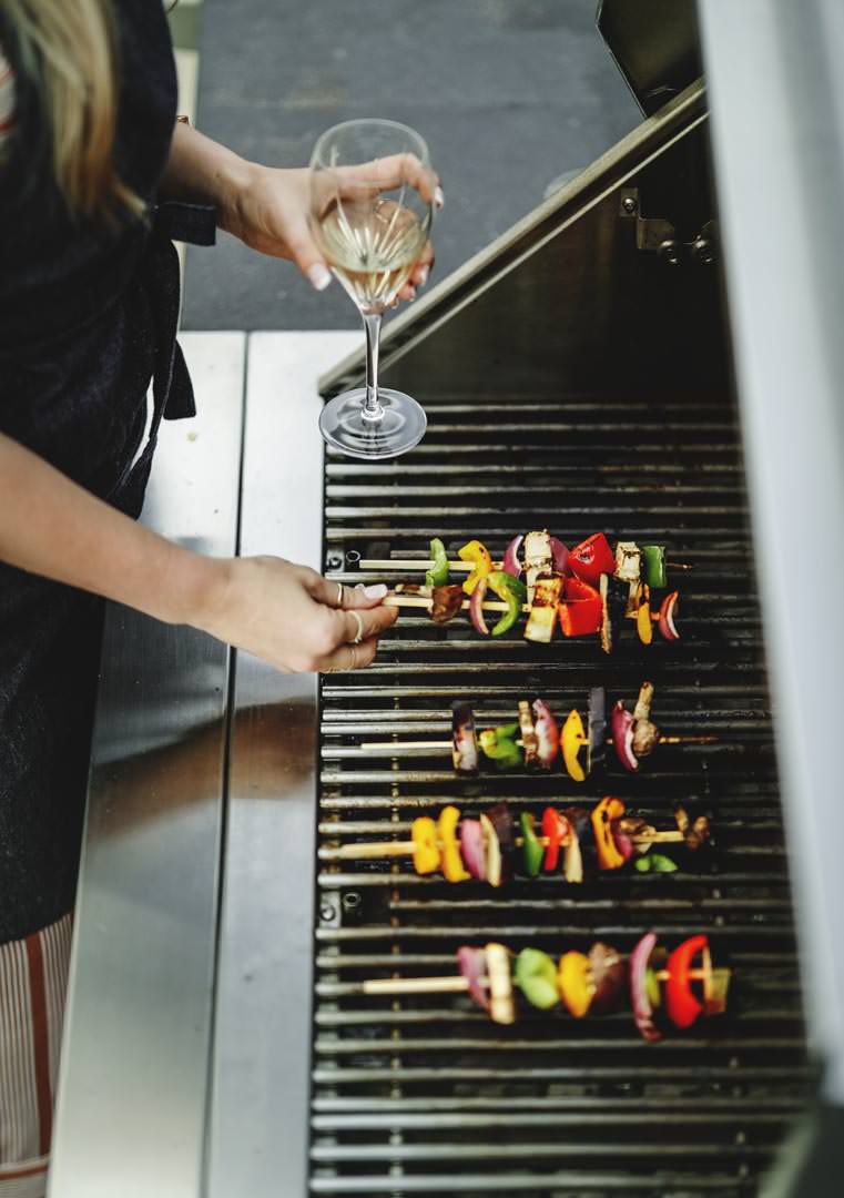 Woman cooking vegan barbecue on a charcoal grill